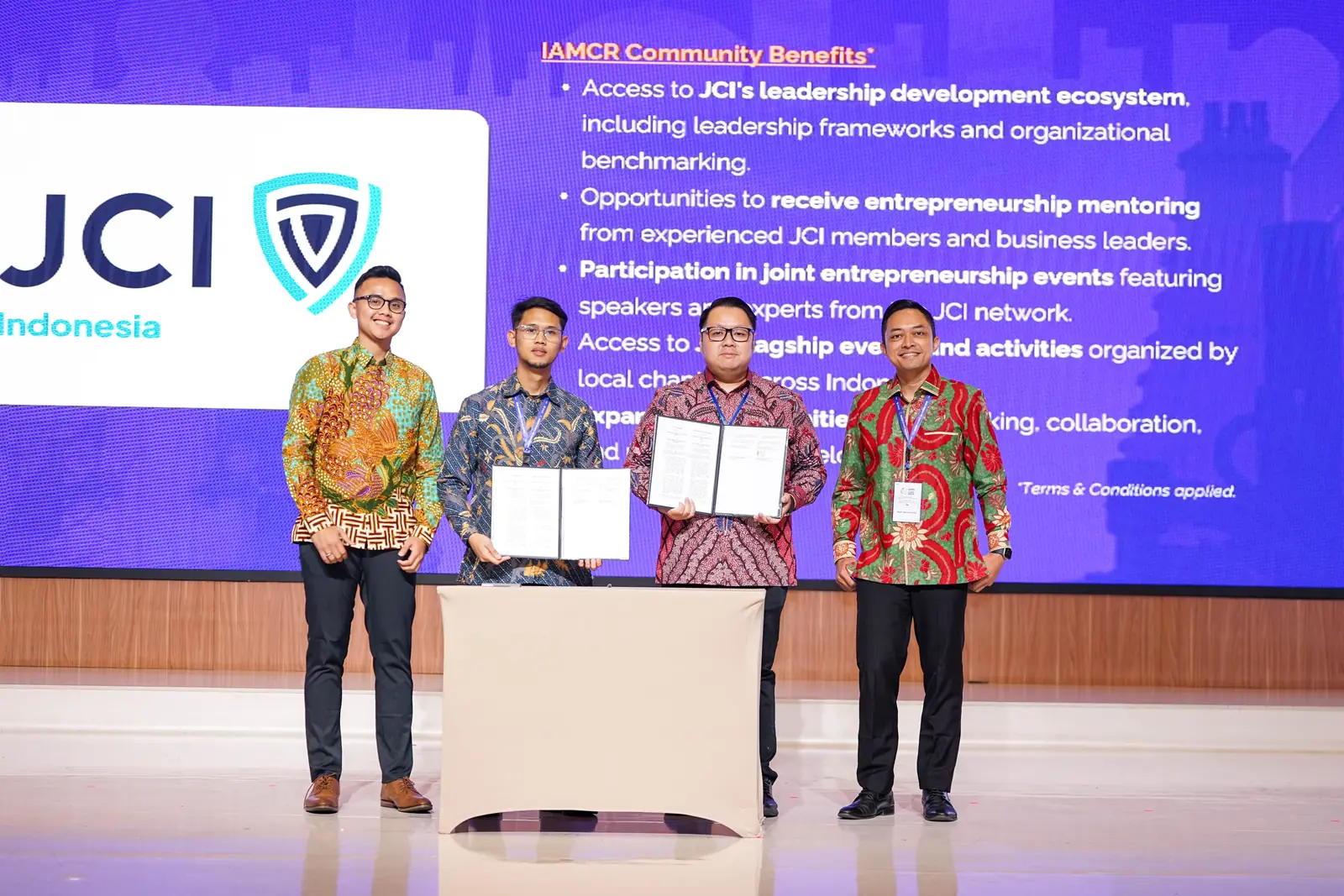 IAMCR and JCI Indonesia representatives holding the signed MoU